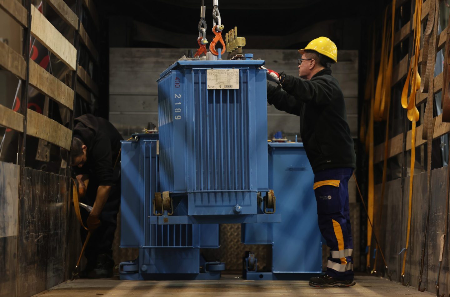 A worker installs a transformer.