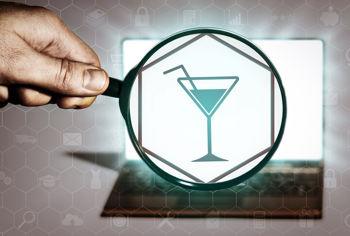 Hand holds the magnifying glass in front of an open notebook. Among the many icons, attention is focused on the cocktail icon. Search for leisure, clubs, parties, entertainment.